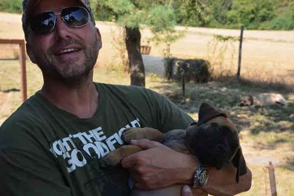 Züchter mit Boerboel Welpen im Arm Boerboel Züchter hält Welpen auf dem Arm